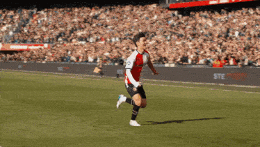 a soccer player is running on the field with the word ste on the side