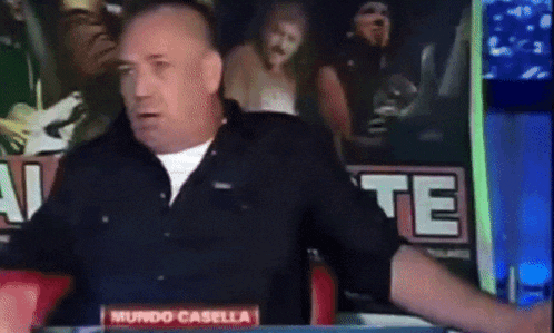 a man sitting at a table with a sign that says mundo casella