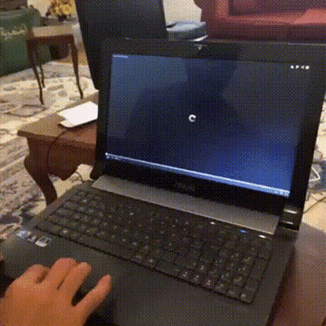 a person is typing on a laptop which has the letter c on the screen