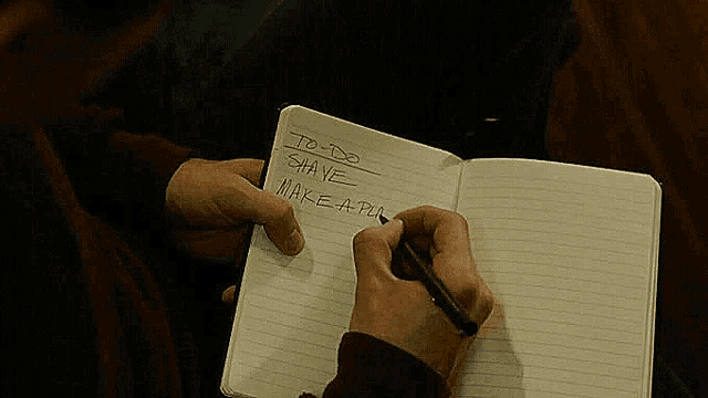 a person is writing in a notebook with the words to do shane make a plan written on it