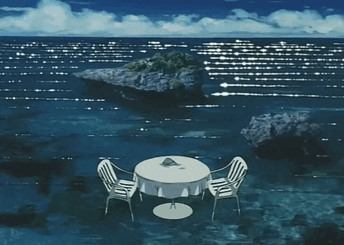 a table and chairs in the middle of the ocean
