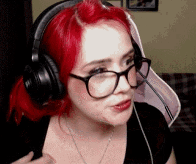 a woman with red hair and glasses is wearing headphones