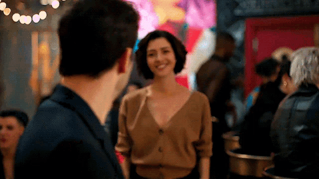 a man and a woman are standing in a crowded room