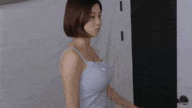 a woman in a blue tank top is standing in front of a door that says jsa on it
