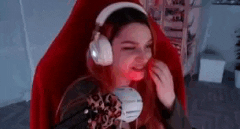 a woman is sitting in a red chair wearing headphones and a microphone .