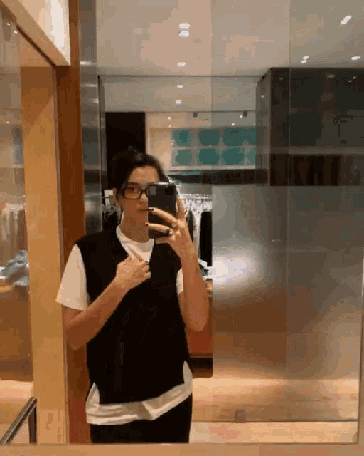 a woman is taking a picture of herself in the mirror