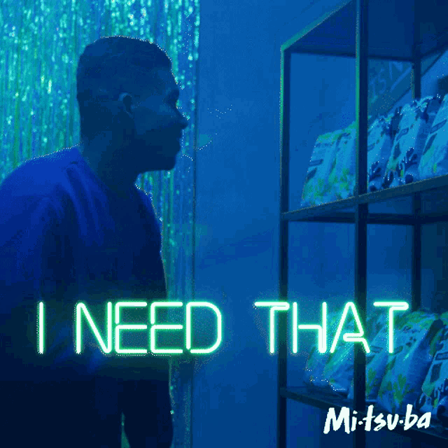 a man standing in front of a shelf that says i need that on it