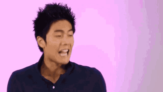 a man in a blue shirt is making a funny face .