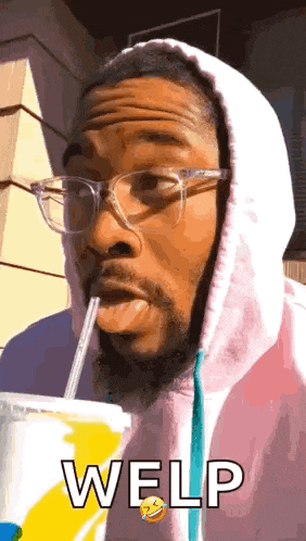 a man wearing glasses and a pink hoodie is drinking through a straw and says welp .