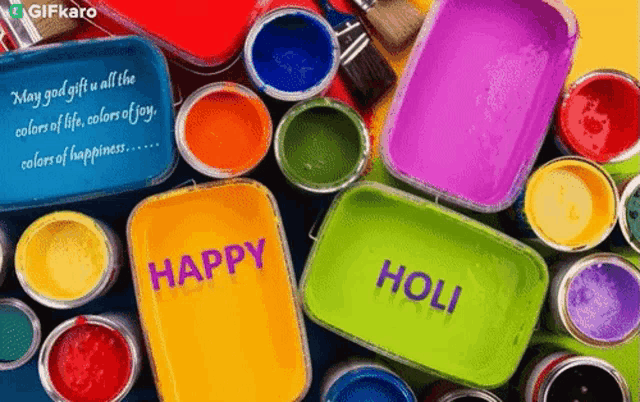 a bunch of cans of paint with a happy holi message on them .