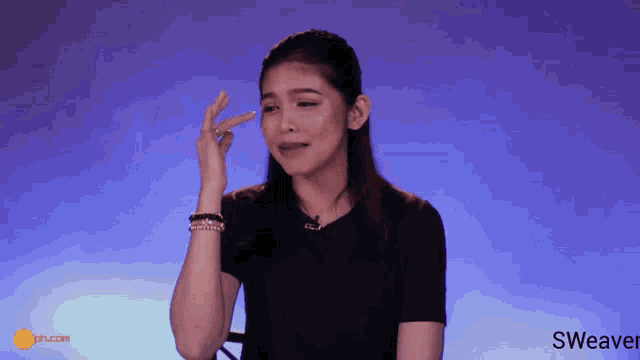 a woman wipes her forehead in front of a blue background that says sweaver on it