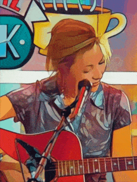 a woman is singing into a microphone while holding a guitar