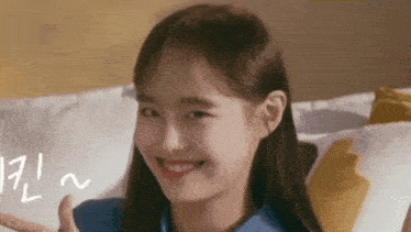a close up of a young woman making a funny face while sitting on a bed .
