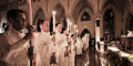a group of people are holding candles in a church at night .