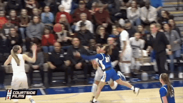 a basketball game is being played in front of a courtside films sign