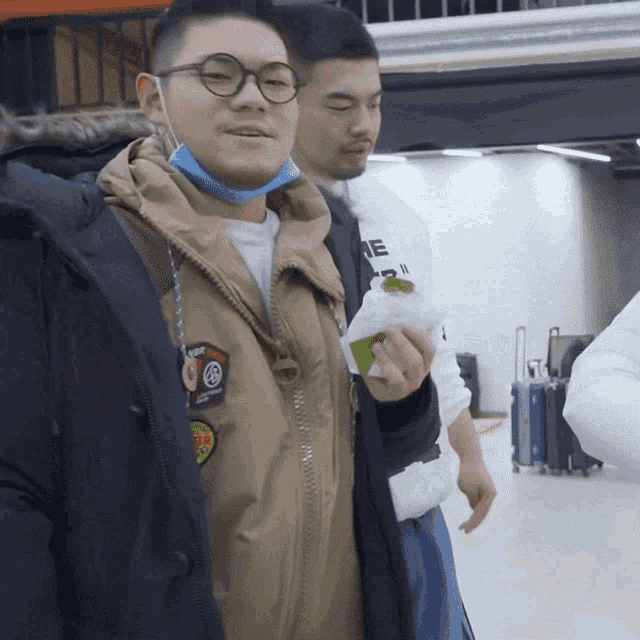 a man wearing glasses and a jacket with a patch that says supreme