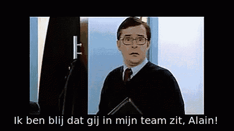 a man in a suit and tie is giving a thumbs up in a foreign language
