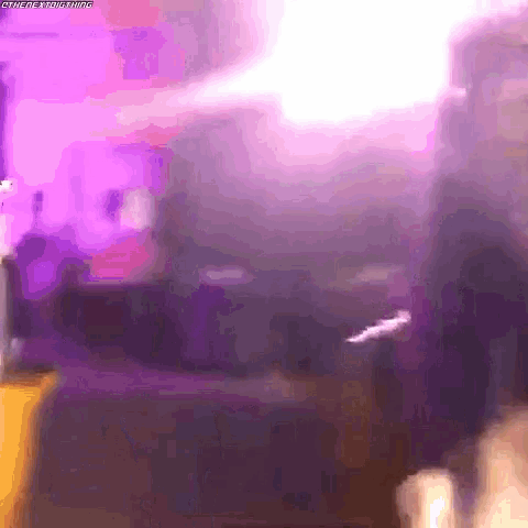 a person is standing in a room with purple lights on the wall .