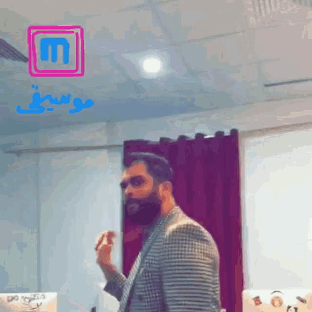 a man with a beard is standing in front of a sign that says m