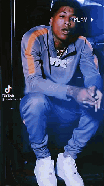 a tik tok video of a man wearing a nike jacket and pants