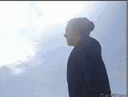 a silhouette of a person standing in front of a blue sky