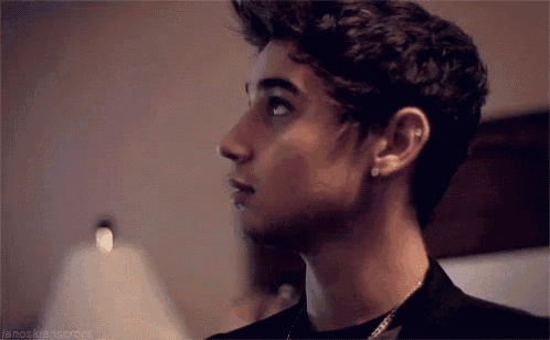 a young man with a piercing in his ear is looking up .