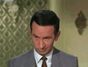 a man in a suit and tie is standing in a room .