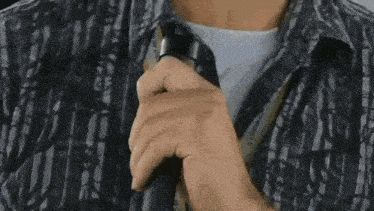 a close up of a man 's neck with a plaid shirt on