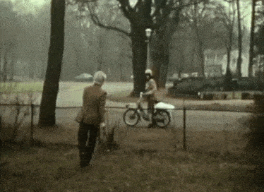 a man on a motorcycle is talking to a man on a bike