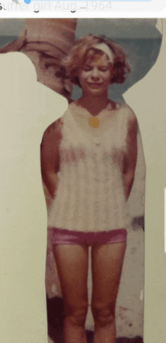 a picture of a woman standing on a beach with the date august 1964