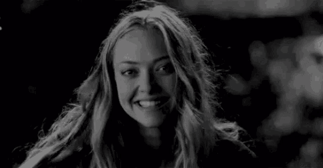 a woman is smiling in a black and white photo .