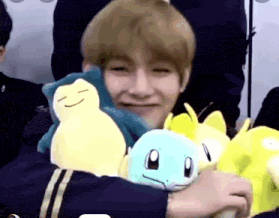 a young man is holding a stuffed animal in his arms .