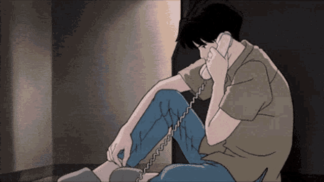 a man sitting on the floor talking on a phone