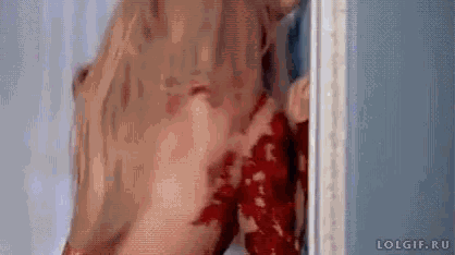 a woman in a red dress is standing next to a door .