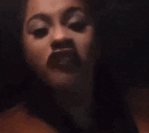 a close up of a woman 's face in a dark room