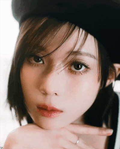 a close up of a woman 's face with her hand on her chin