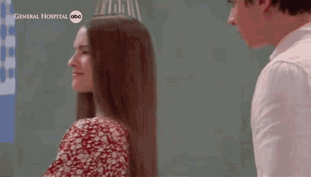 a man and a woman are standing next to each other in front of a general hospital abc logo