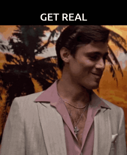 a man wearing a suit and a pink shirt with the words get real above him