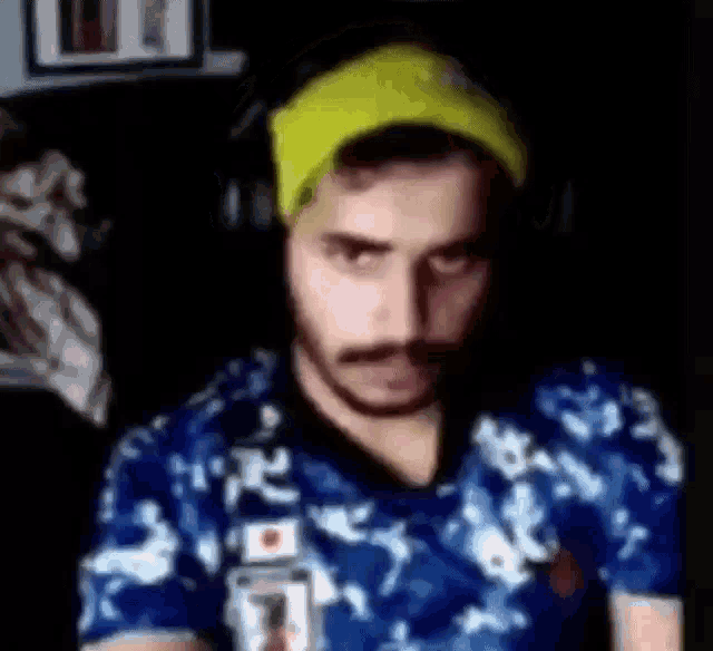 a man with a beard and mustache is wearing headphones and a yellow beanie .