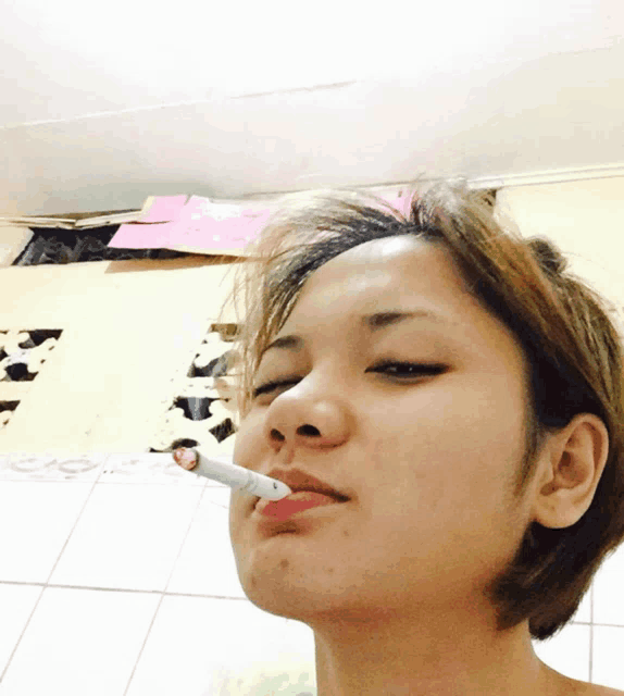 a woman smoking a cigarette with a pink lip gloss on her lips