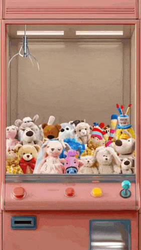 a pink claw machine filled with stuffed animals including a stuffed cow
