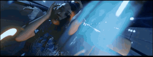 a woman in a blue dress is laying on a blue surface