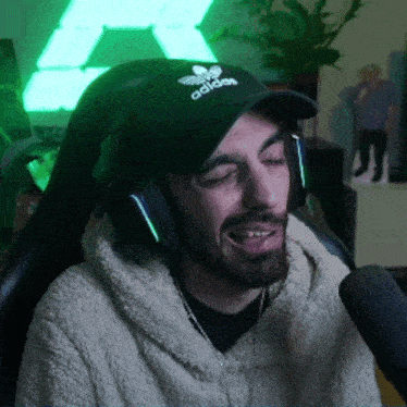a man wearing an adidas hat and headphones