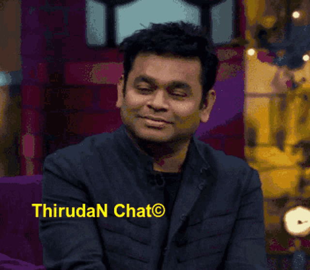 a man sitting in front of a sign that says thiruda chat