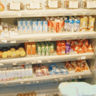 a blurred image of a grocery store shelf filled with lots of food items