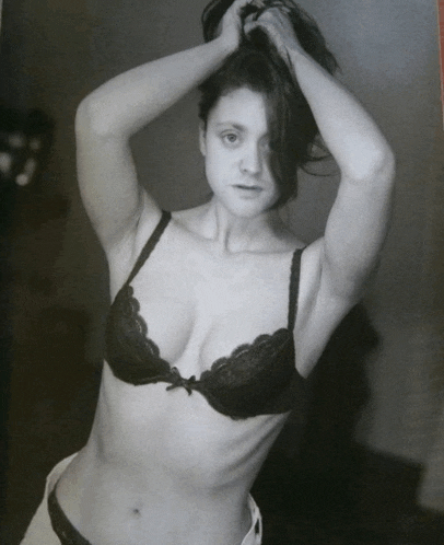 a black and white photo of a woman in a lace bra