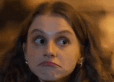 a woman is making a funny face with her eyes closed .