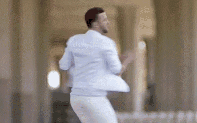 a man in a white shirt and white pants is dancing .