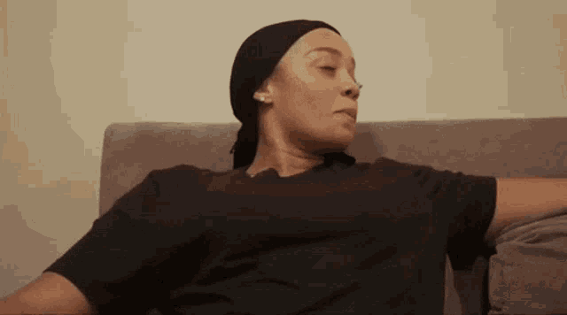 a woman wearing a head scarf is sitting on a couch .