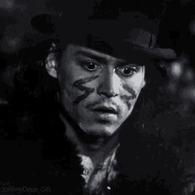 a black and white photo of johnny depp 's face with a hat